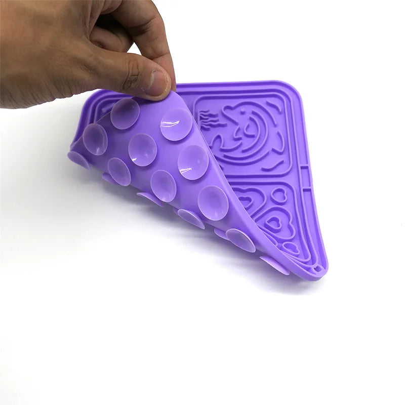 Hand bending a flexible purple silicone lick mat