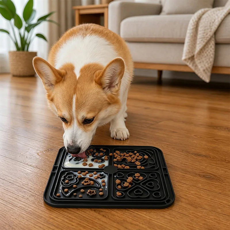 Corgi licking food from a black silicone lick mat